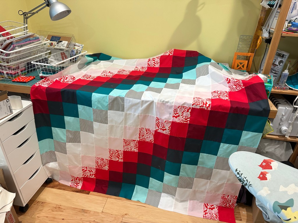 Pieced together quilt top using squares.